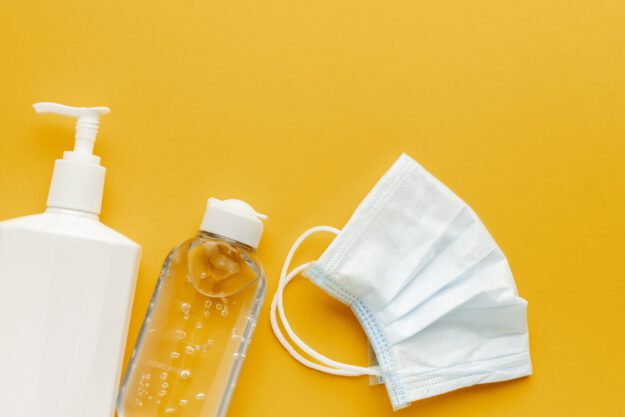 flat-lay-medical-mask-with-liquid-bottle-hand-sanitizer